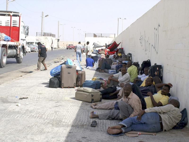 Another useless wall? Sudanese workers rest as they wait for Egyptian visas next to the Libyan-Egyptian border crossing in Musaid.