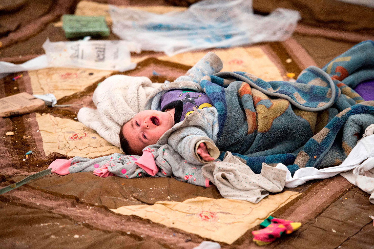 A baby cries at the Internally Displaced Persons (IDP) camp of al-Hol in al-Hasakeh governorate in northeastern Syria on February 6, 2019.