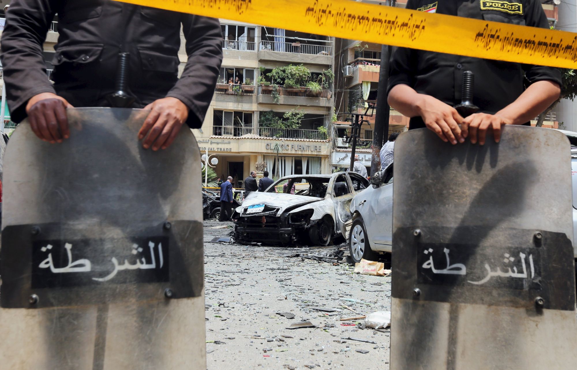 Policemen investigate the site of a car bomb attack on the convoy of Egyptian public prosecutor Hisham Barakat near his house at Heliopolis district in Cairo, Egypt, June 29, 2015.