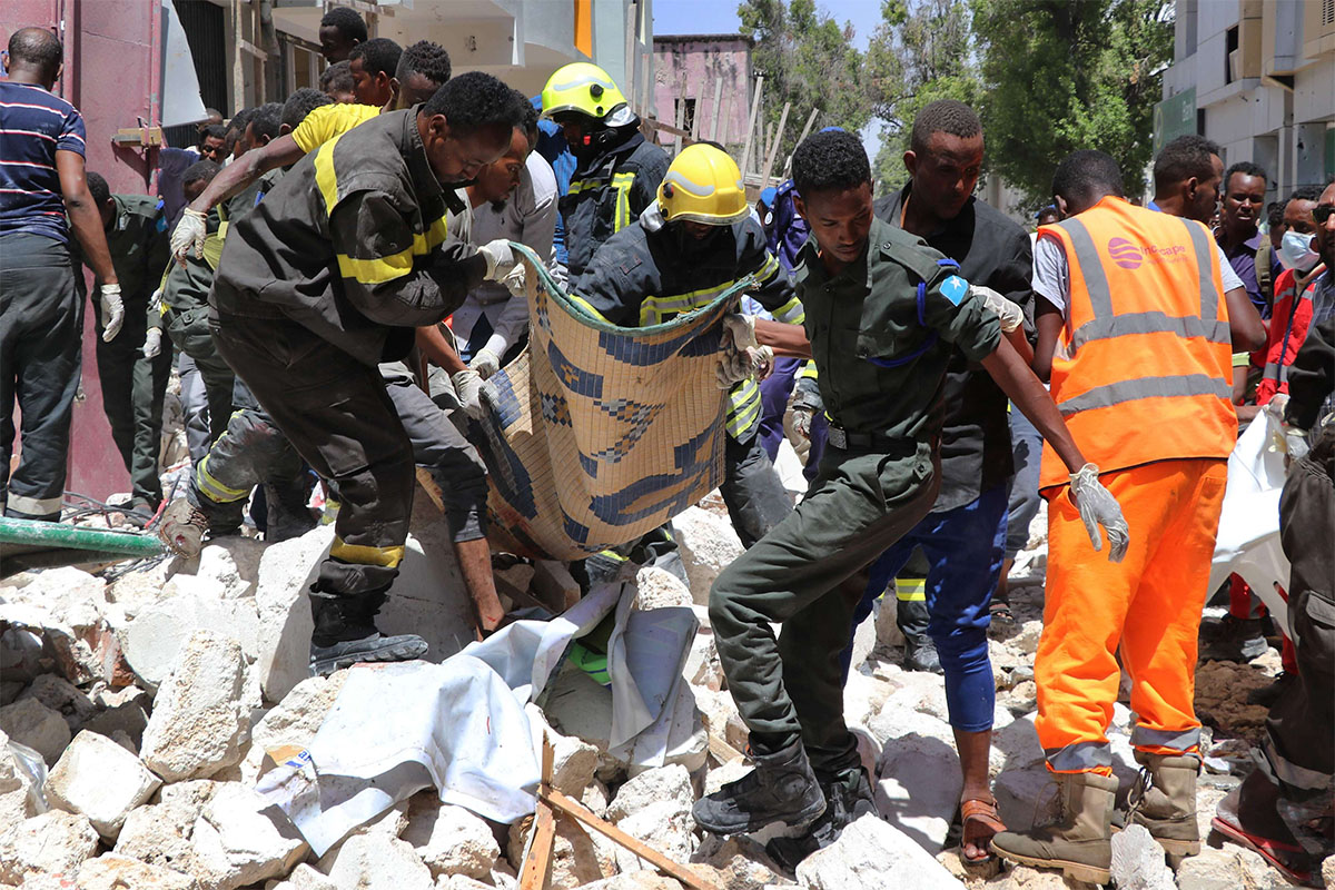 Emergency rescue staff carry the body of a victim over rubble at the scene of the car-bomb attack