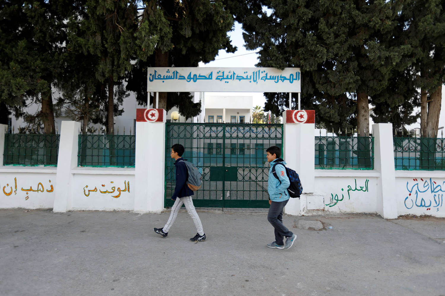 أطفال تونسيون يمرون من أمام مدرسة مغلقة بسبب الاضراب