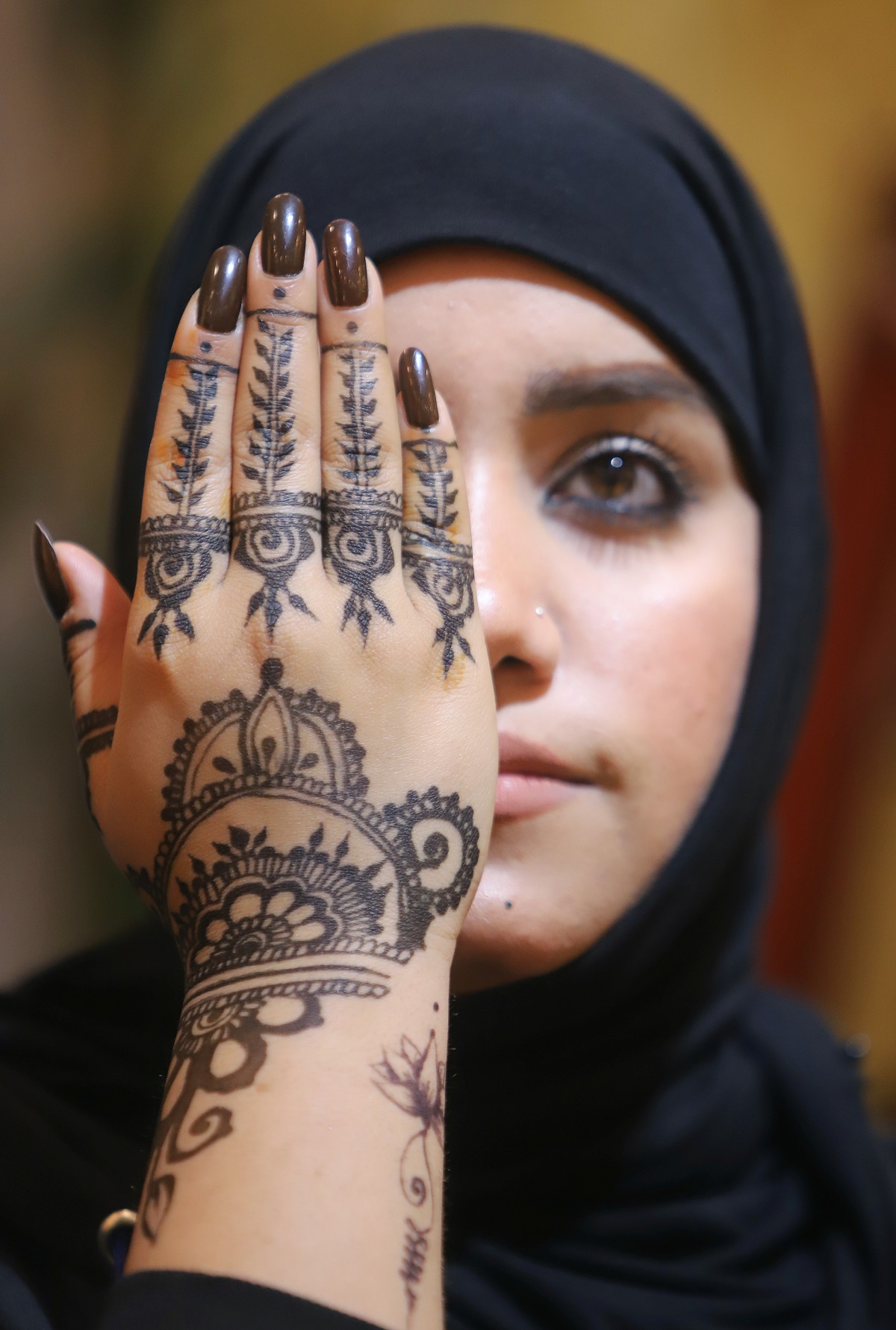 فتاة عراقية تخضب كفها بالحناء في صالون تجميل في البصرة