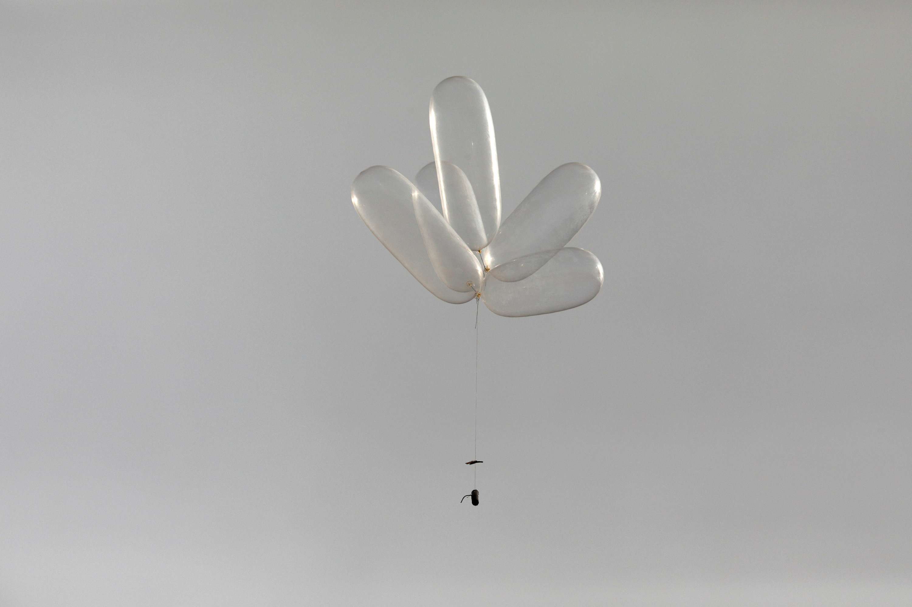Balloons connected to a device can be seen as Palestinians protest near the fence separating the Gaza Strip on October 19, 2018.