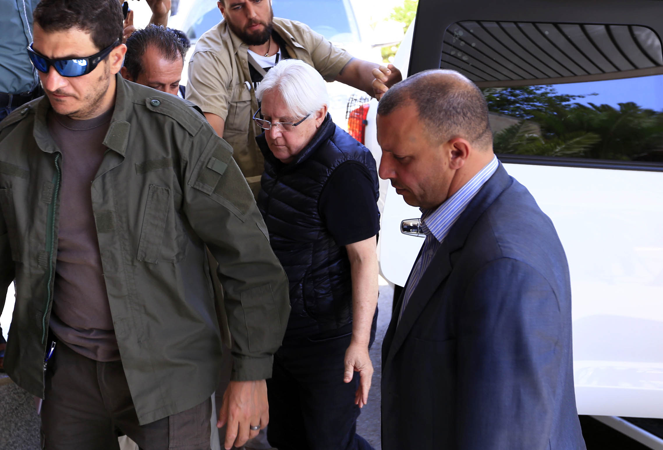 Martin Griffiths (C), the UN special envoy for Yemen, is surrounded by his personal security detail as he departs the Yemeni capital Sanaa on February 28, 2019 at the international airport.