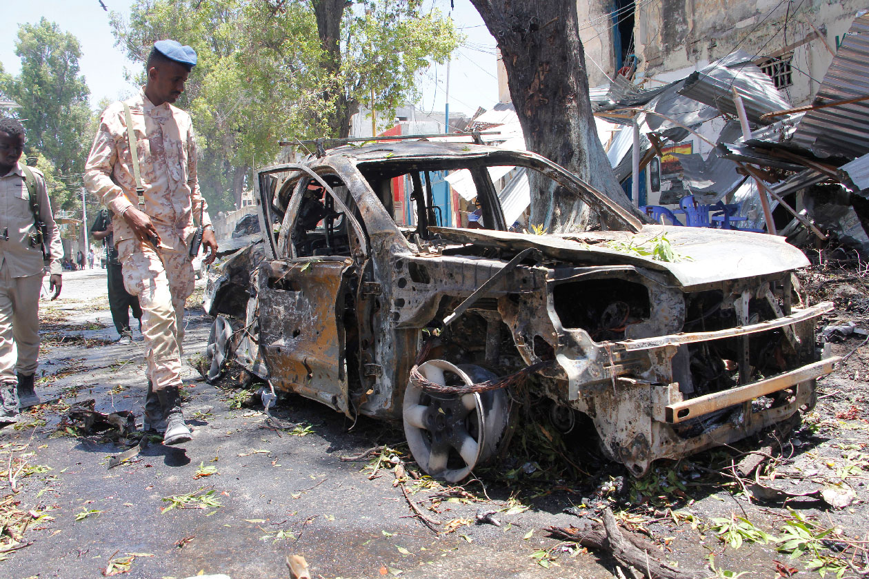 A Somali soldier walks near the wreckage of a car in Mogadishu, Somalia, Thursday March 7, 2019.