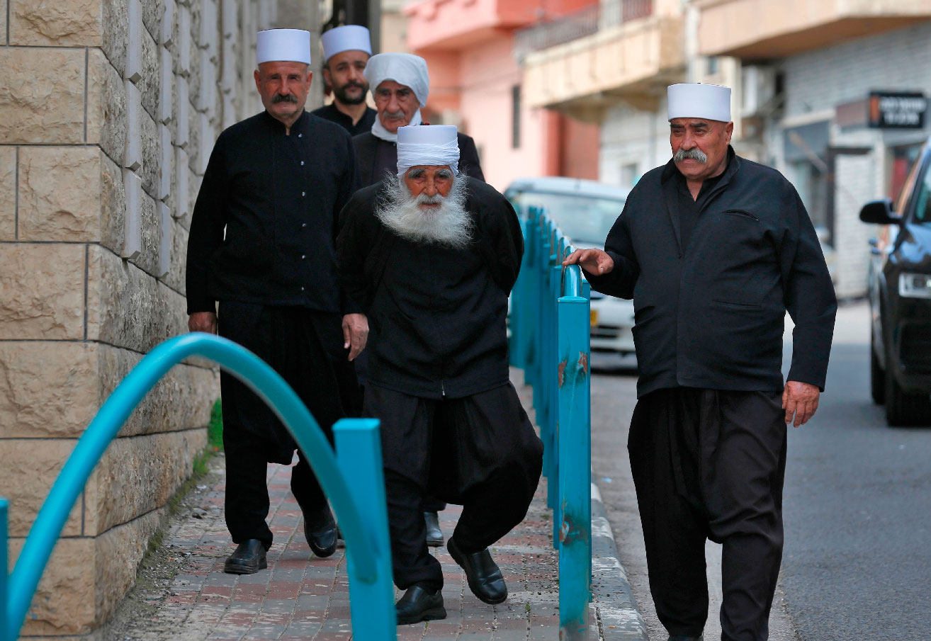 Syrian Druze men walk down a street in the Majdal Shams village in the Israeli-occupied Golan Heights on March 22, 2019.