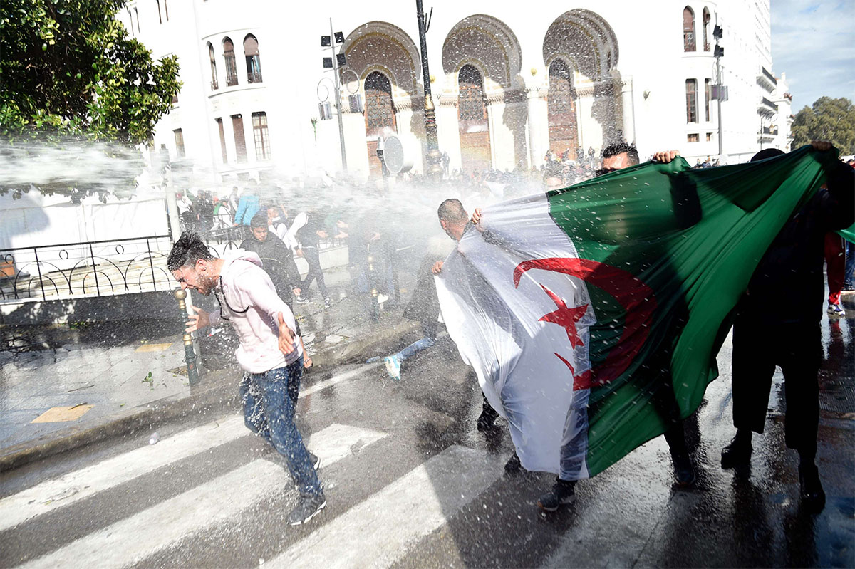 Riot police spray protesters with water during a protest in Algiers against Bensalah's appointment