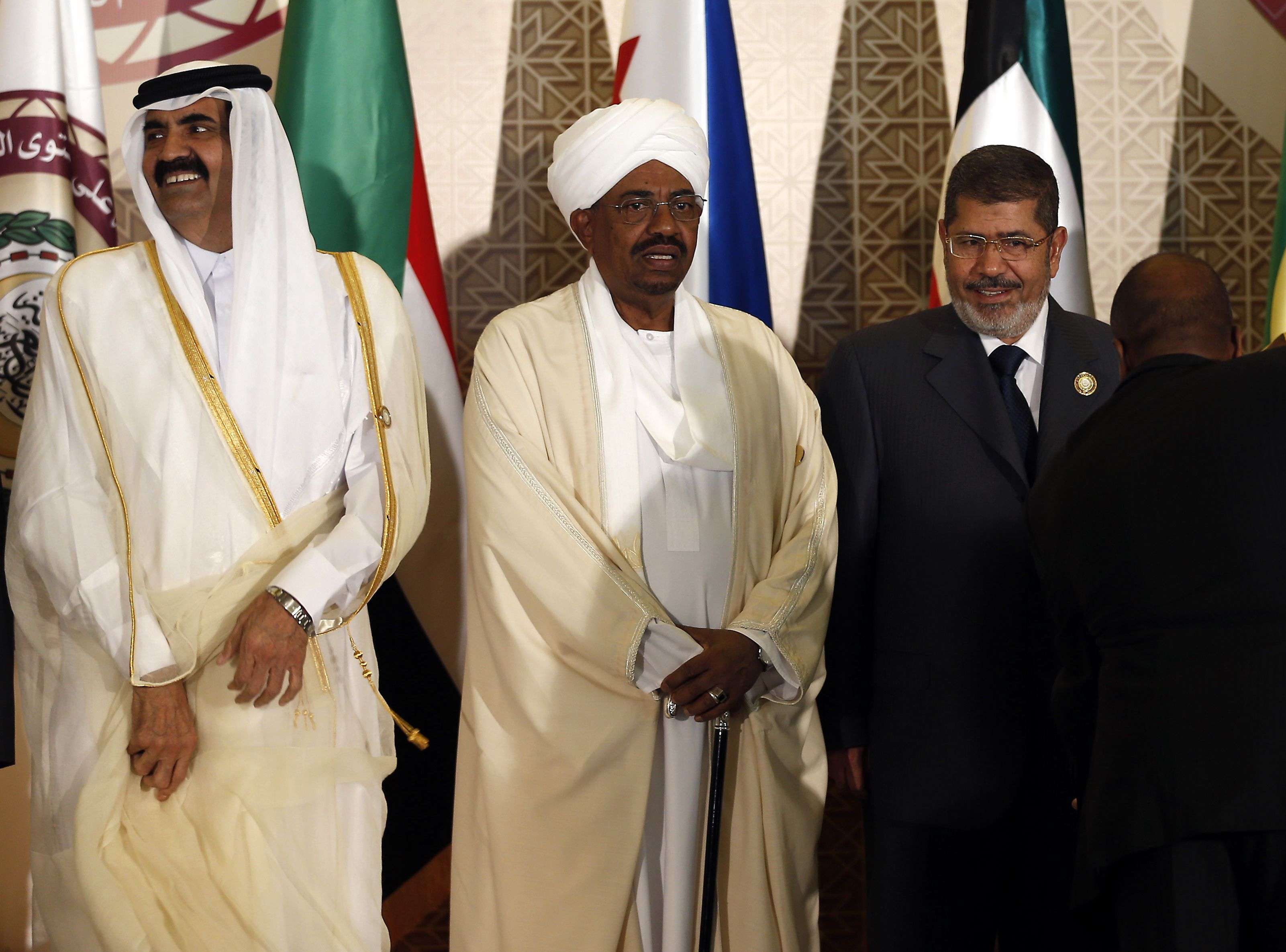 البشير يتوسط الرئيس المصري المعزول محمد مرسي وأمير قطر السابق الشيخ حمد بن خليفة آل ثاني