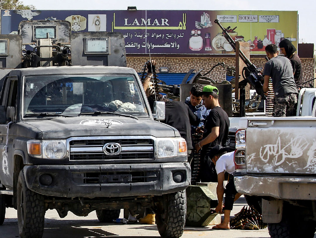 This picture taken on April 10, 2019 from the side of forces loyal to Libya's Government of National Accord (GNA) shows a view of fighters gearing up by technicals (improvised pickup trucks mounted with turrets) at the frontline during clashes with forces loyal to strongman Khalifa Haftar south of the capital Tripoli's suburb of Ain Zara.