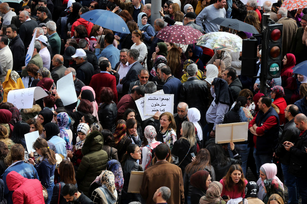 Public sector workers hold banners during a protest against any cuts to their salaries in the budget, in downtown Beirut