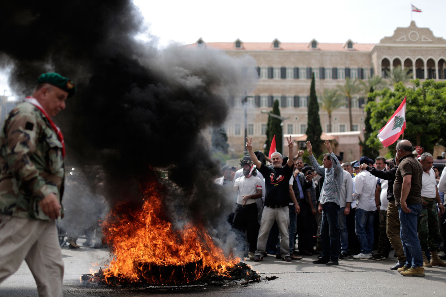 Lebanese retired soldiers burn tires as they protest in front of the government building during a cabinet meeting to discuss an austerity budget