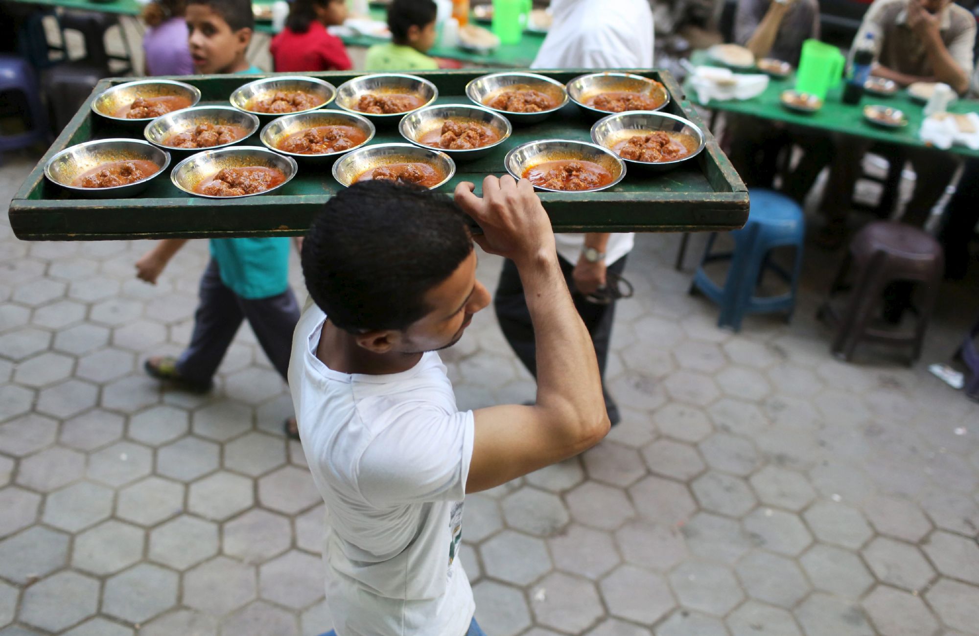 A volunteer carries food to charity tables in Cairo