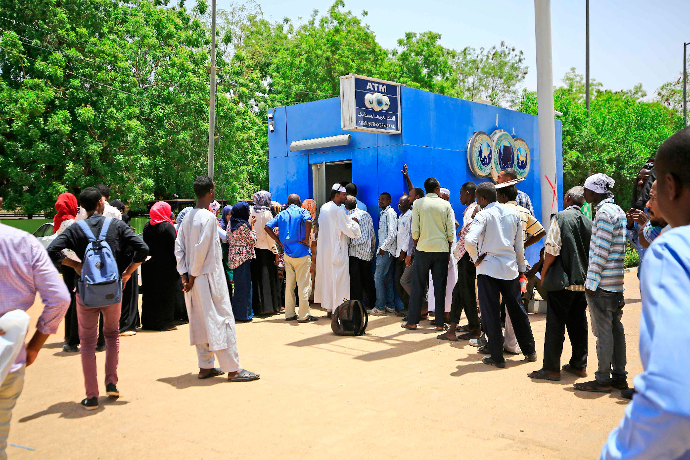 Sudanese people queue up to withdraw money from an ATM in Sudan's capital Khartoum.