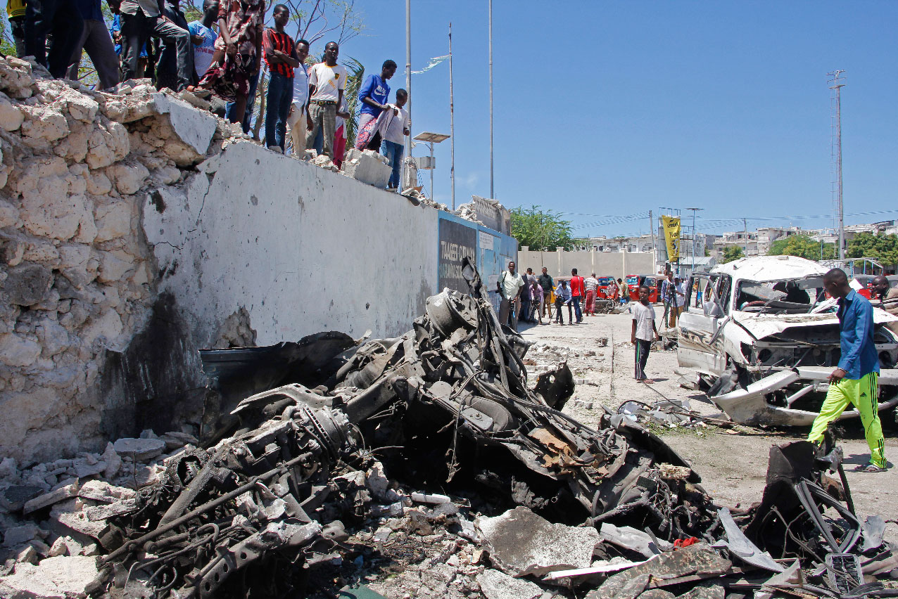 Somalis look at the wreckage after a suicide car bomb attack in the capital Mogadishu