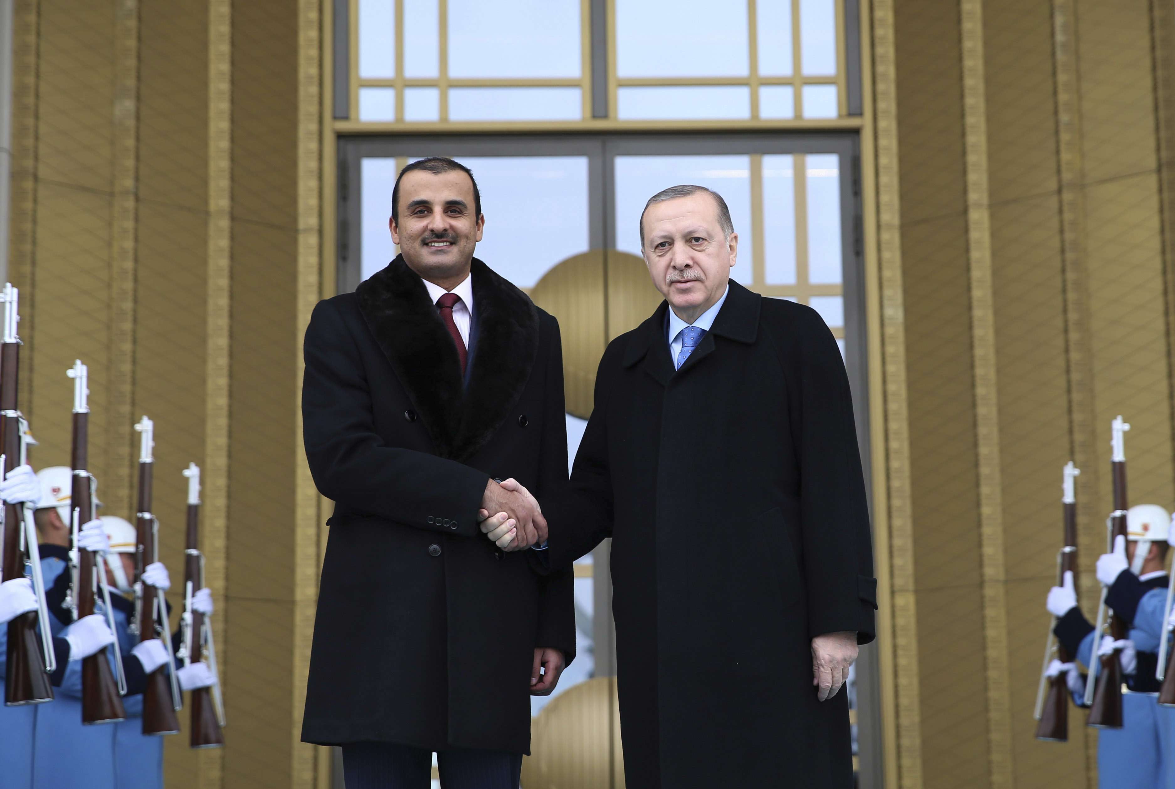 Turkey's President Recep Tayyip Erdogan, right, shakes hands with Qatar's Sheikh Tamim bin Hamad Al Thani