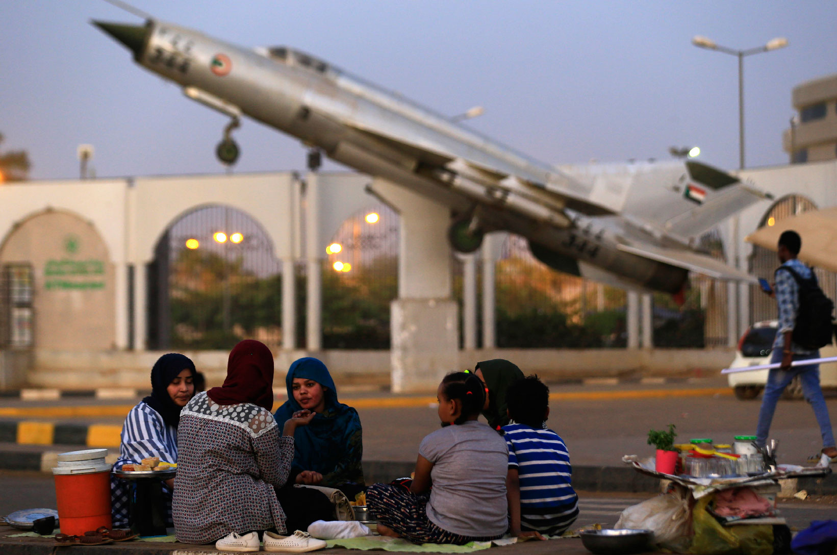 Sudanese protesters share an Iftar meal as they continue to gather outside the military headquarters in the capital Khartoum