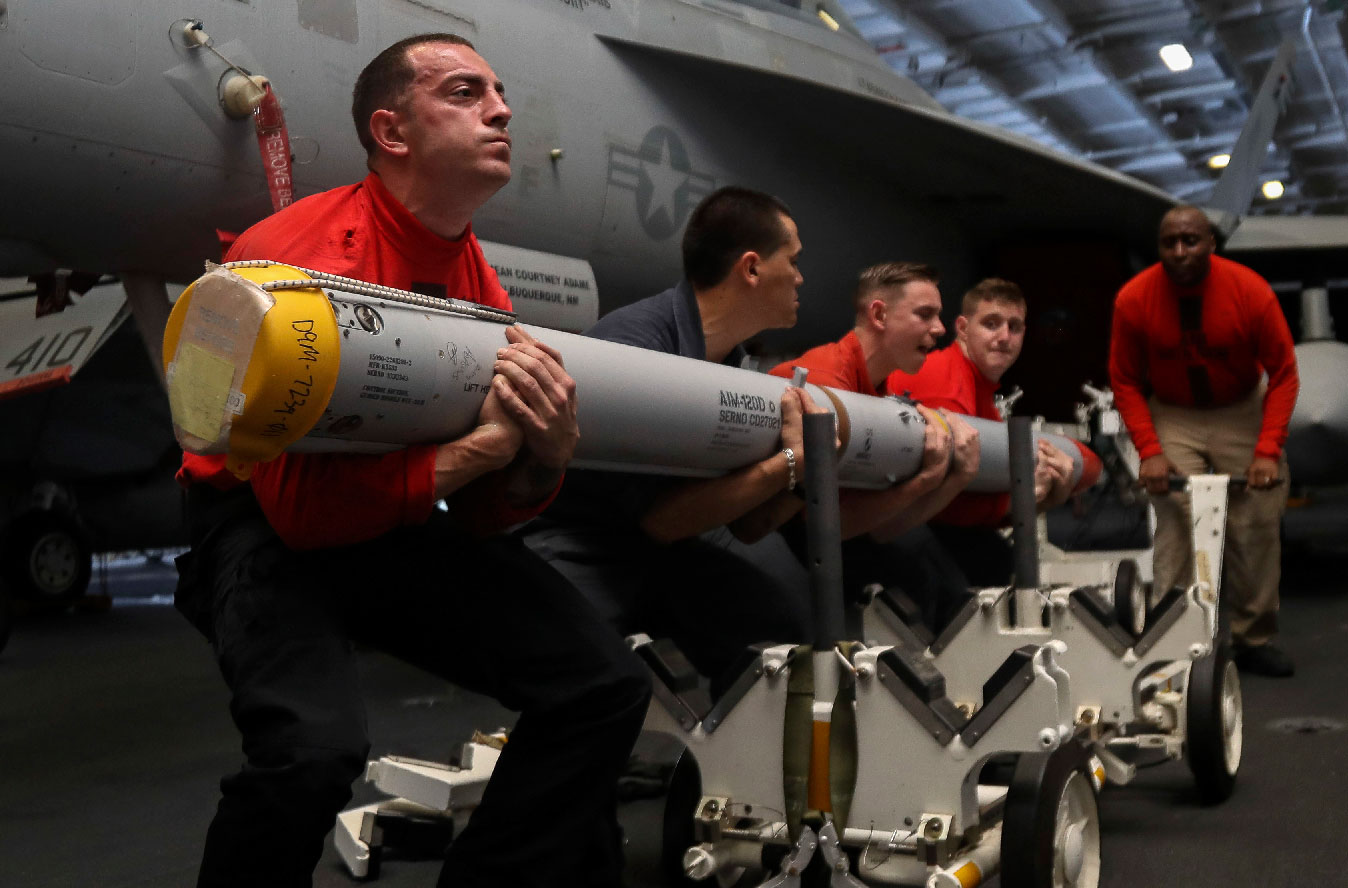 US Navy personnel transport a missile aboard the Nimitz-class aircraft carrier USS Abraham Lincoln in the Persian Gulf