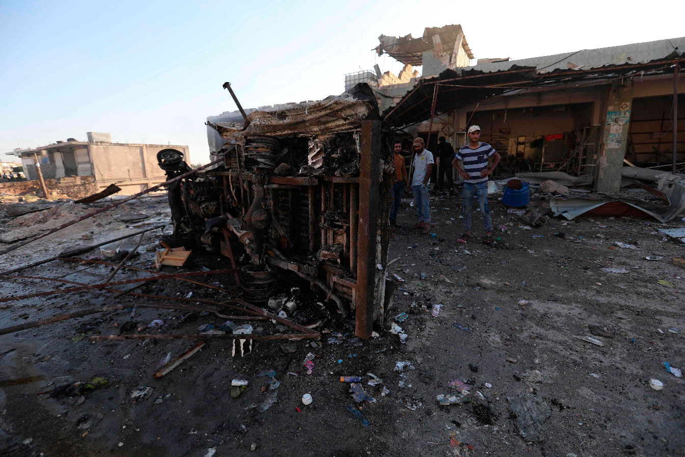 Syrians gather at the site of regime bombardment on the village of Kafr Halab