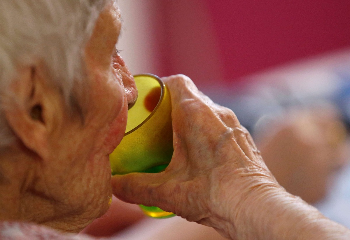 سيدة مسنة تشرب كأس ماء في إحدى دور الرعاية الصحية في فرنسا