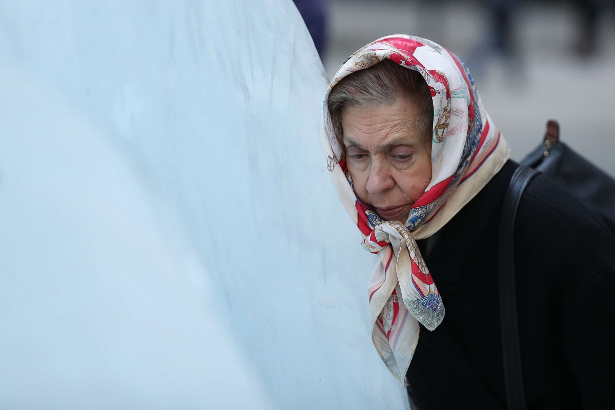 امرأة تضع رأسها على كتلة جليدية في معرض ألماني يدعو لمواجهة التغير المناخي 