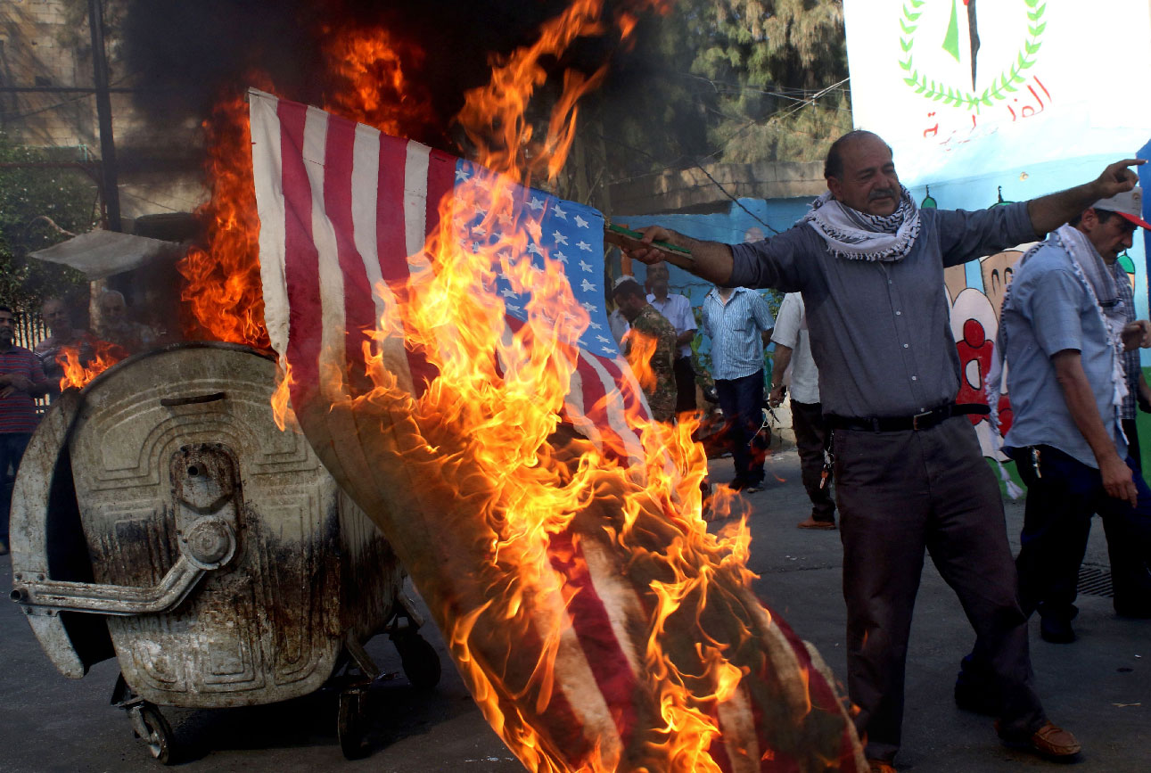 Palestinian refugees in Lebanon's Ain el-Helweh camp burn the US flag during a protest against the Manama conference