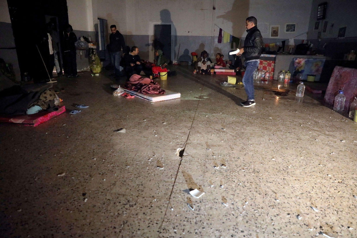 Migrants sit inside the Anti-Illegal Immigration Agency in Tajora shelter center, Tripoli