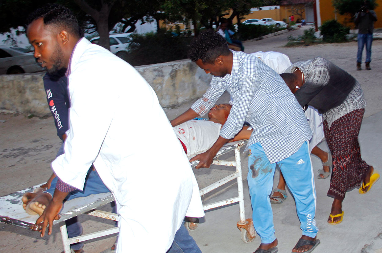 Medical workers help civilian on stretcher who was wounded in the suicide bombing