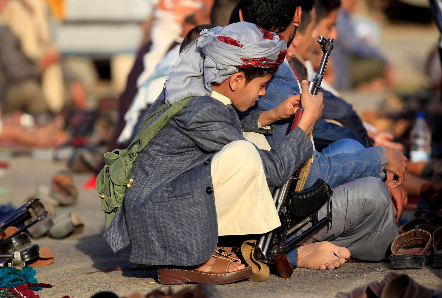 طفل يحمل سلاحا خلال الصلاة في مسجد في صنعاء