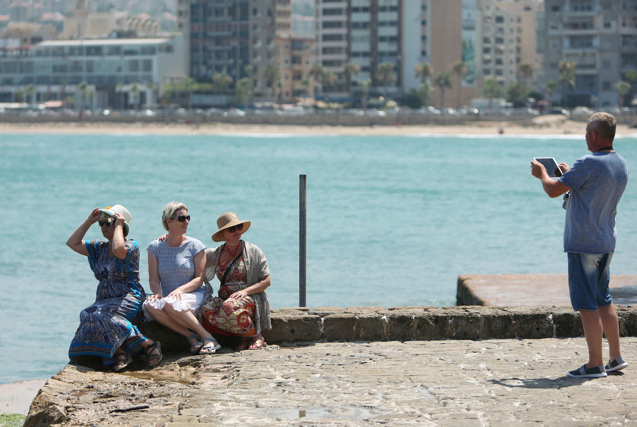 A tourist uses an iPad to take a picture of fellow tourists at the sea castle in the port city of Sidon