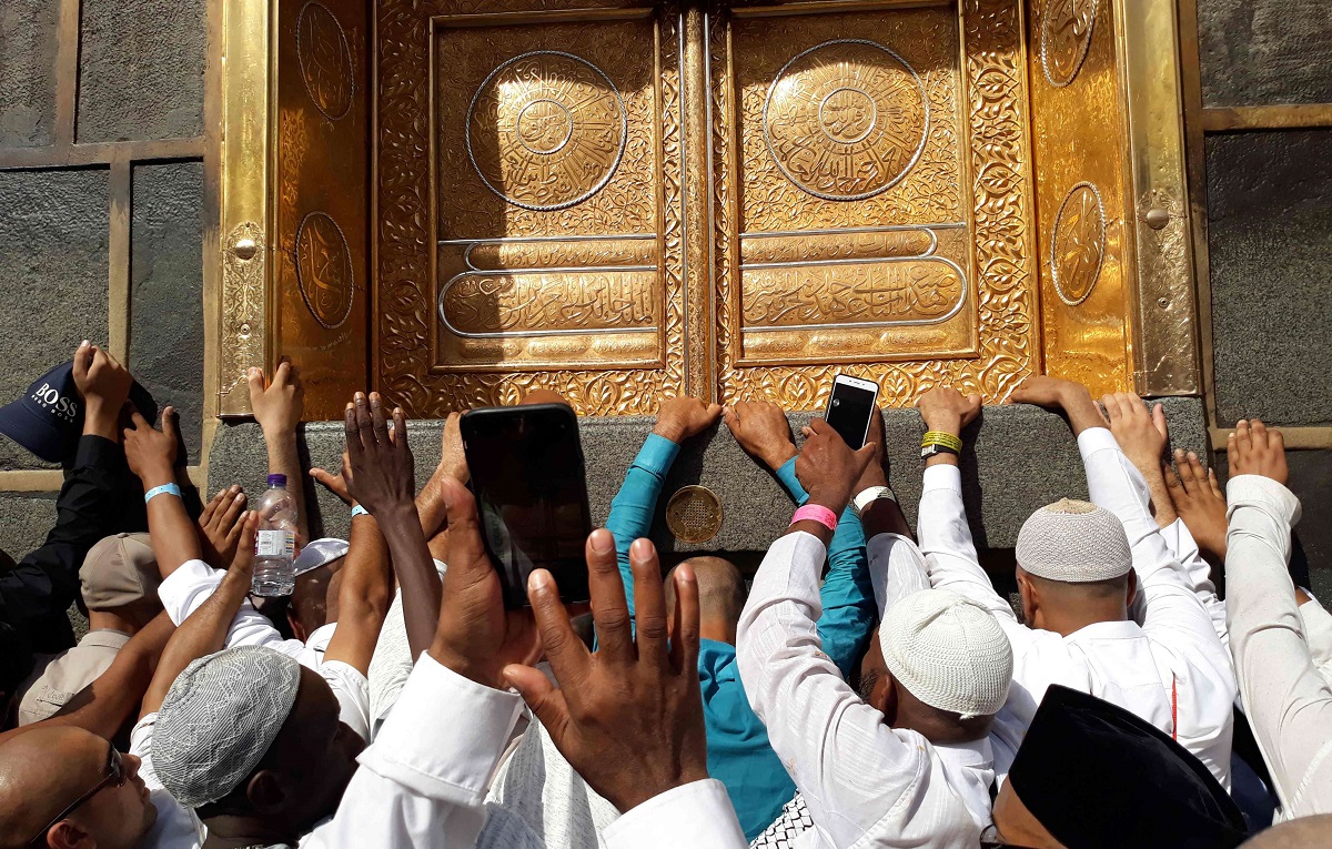 حجاج يصورون بهواتفهم الذكية جانبا من الطواف حول الكعبة