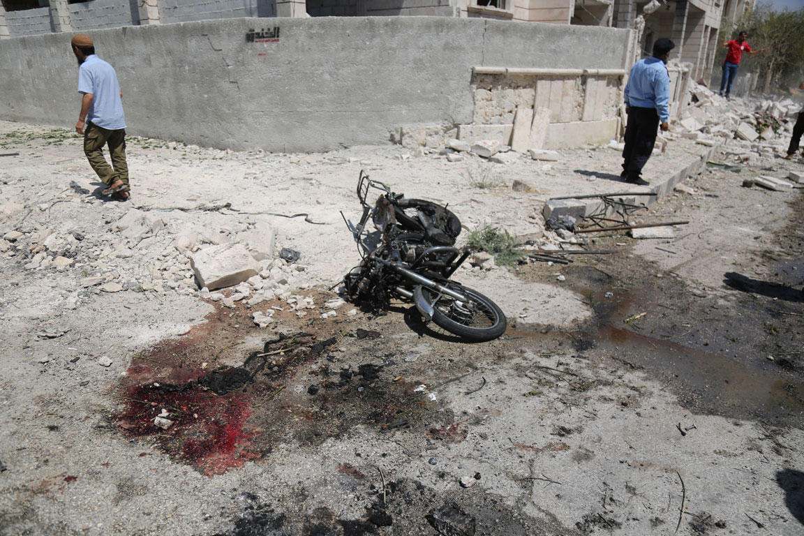 Blood seen next to a damaged motorcycle after an explosion hits a residential neighbourhood in Idlib