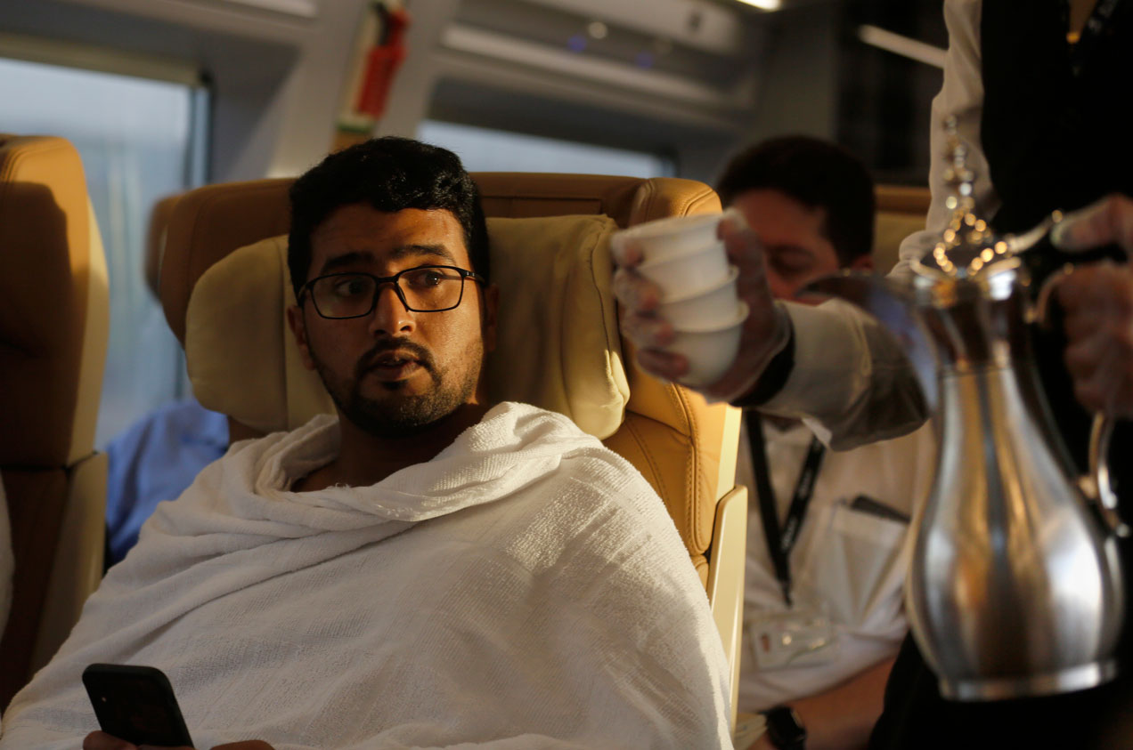 A Pilgrim on his way to Mecca is served Arabic coffee on the Haramain High-Speed Railway train in the holy city of Medina