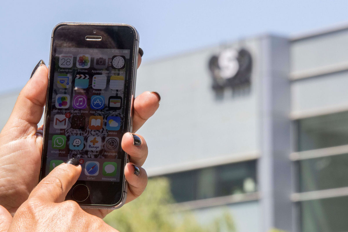 An Israeli woman uses her smartphone in front of the building housing the Israeli NSO group