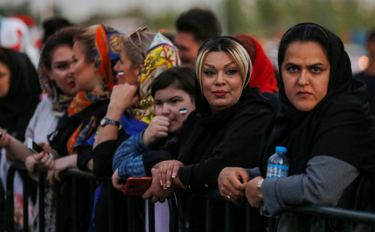 Iranian women wearing facepaint of the national flag arrive outside Azadi stadium in the capital Tehran