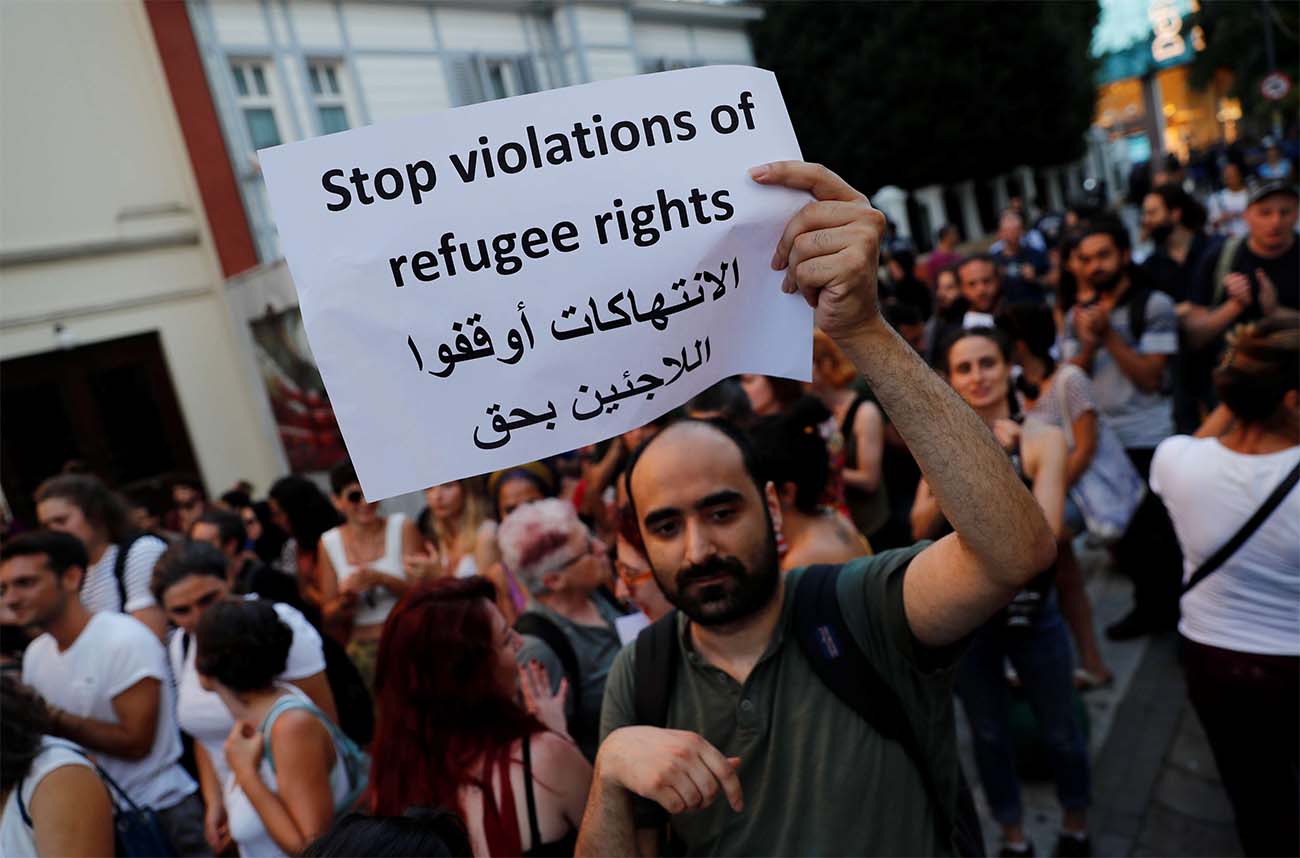 A demonstrator holds a placard during a protest against Turkish government's recent refugee policies in Istanbul