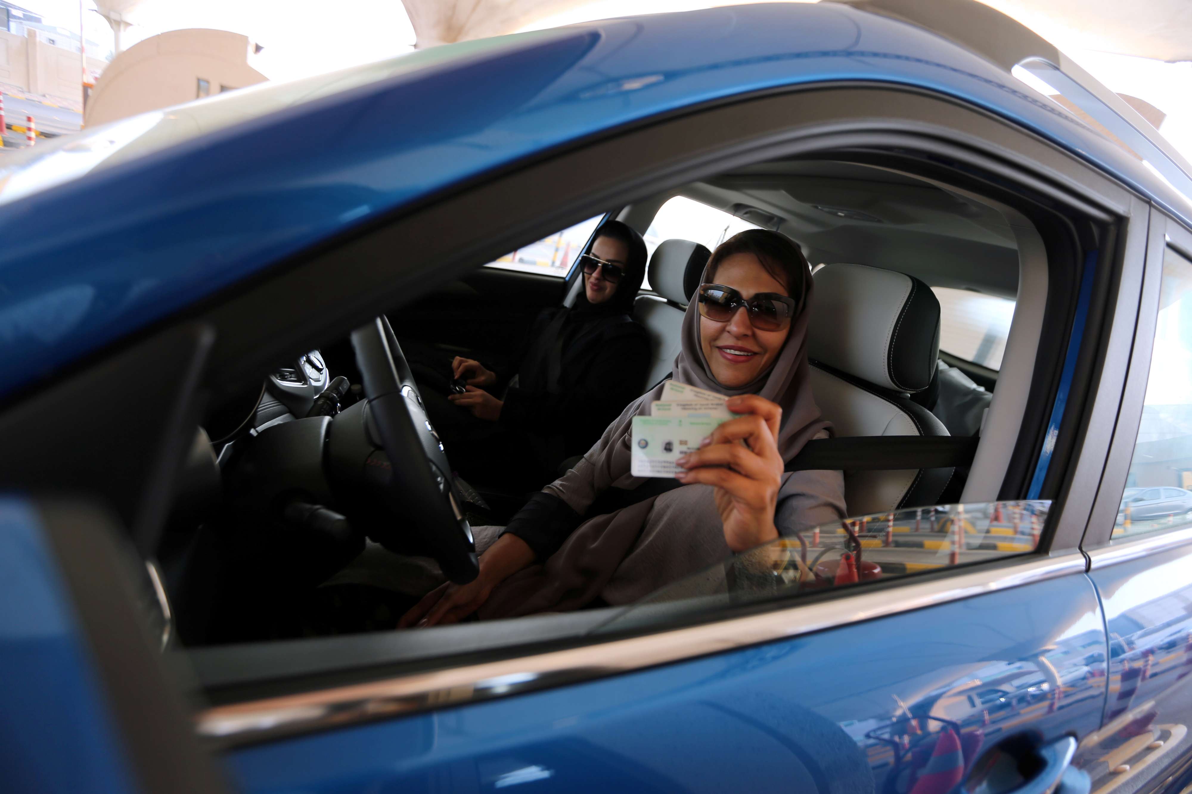 A Saudi woman smiles with her national ID at the Bahrain immigration checkpoint