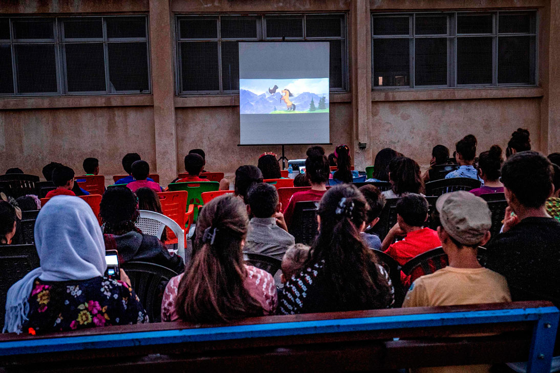 Children attend a film screening as part of the mobile cinema "Komina Film" initiative