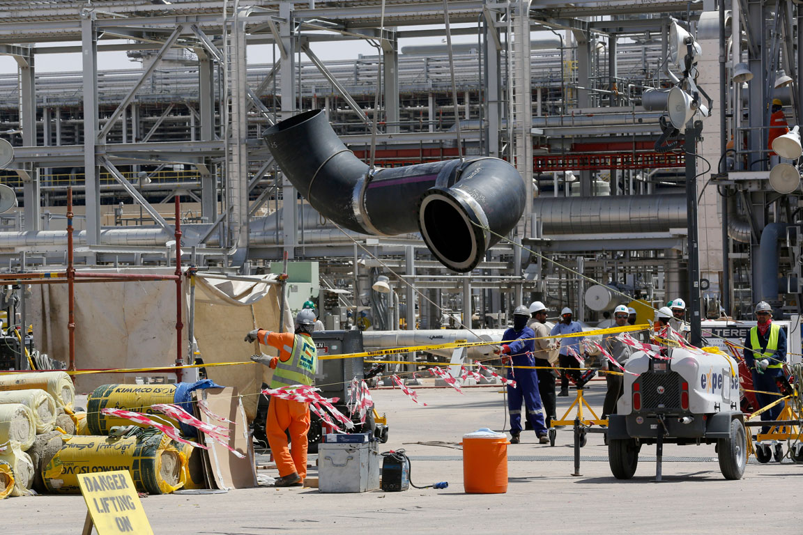 Workers replace a damaged tube at Saudi Aramco's Khurais oil field