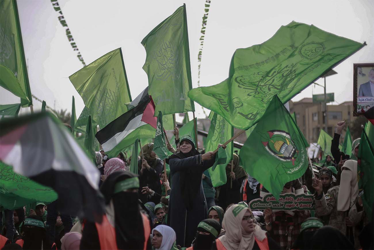 Palestinian women wave green Hamas flags during a rally marking the 31st anniversary of the founding of the Islamist movement Hamas last year
