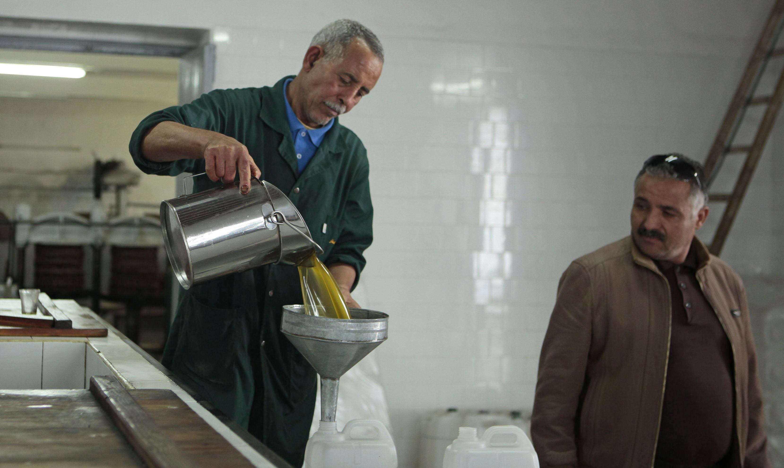 A worker pours olive oil at a traditional factory in Tebourba, 30km from Tunis