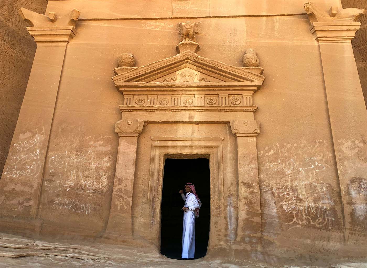 A Saudi tour guide stands inside a tomb at Mada'in Saleh antiquities site