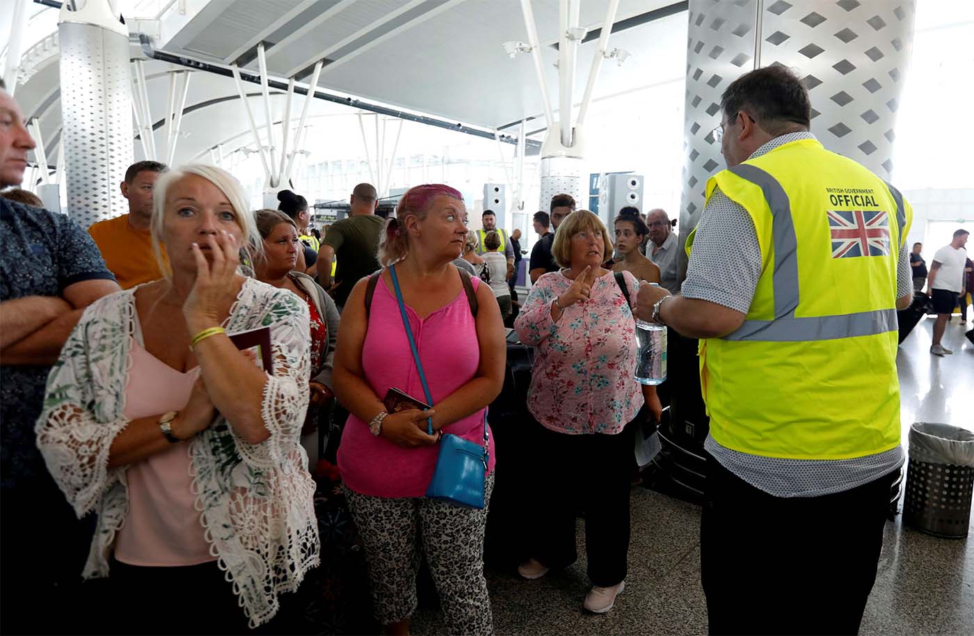 A British government official speaks to tourists, flying with Thomas Cook at Enfidha-Hammamet International Airport