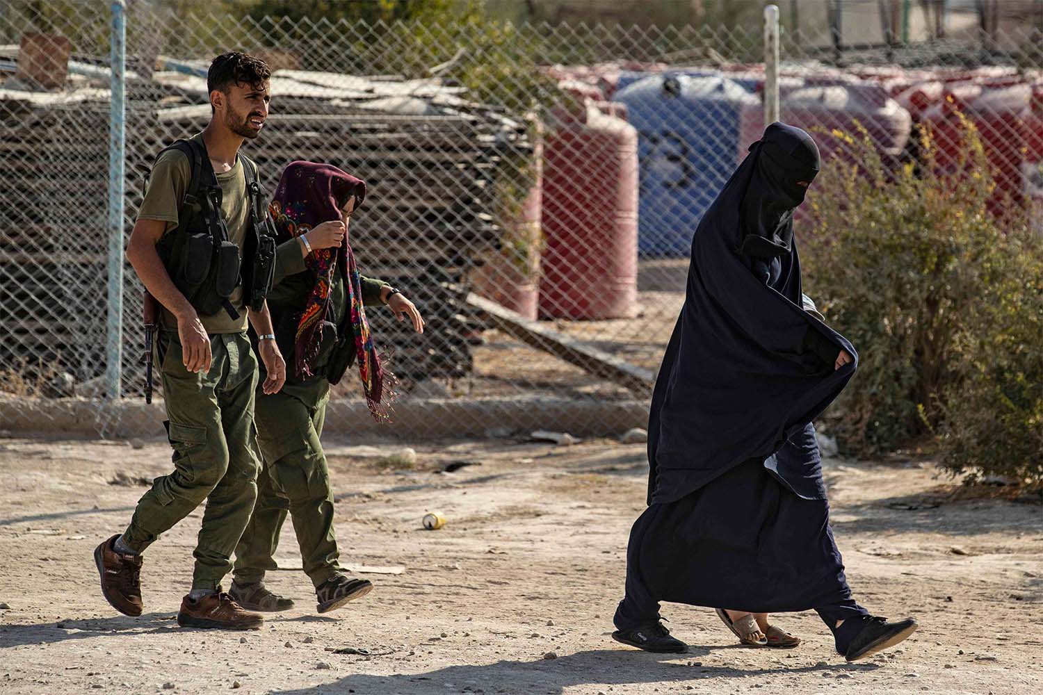 Guards accompanying women at the Kurdish-run al-Hol camp for the displaced where families of Islamic State (IS) foreign fighters are held, in the al-Hasakeh governorate in northeastern Syria