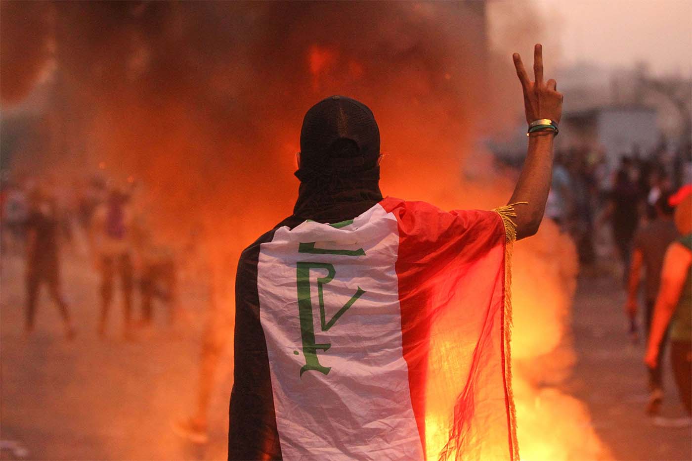 An Iraqi protester gestures the v-sign during a demonstration against state corruption, failing public services and unemployment at Tayaran square in Baghdad