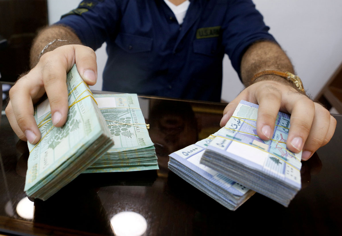 A money exchange vendor displays Lebanese pound banknotes at his shop in Beirut