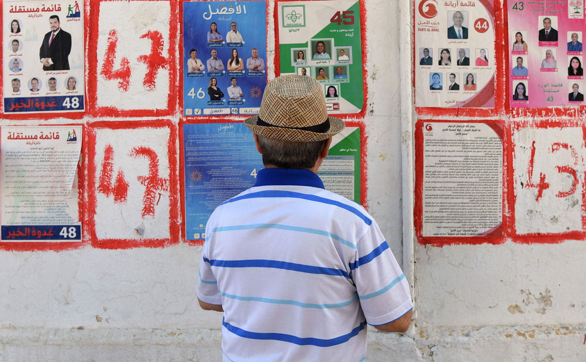 A Tunisian man looks at posters of legislatives' candidates in the capital Tunis
