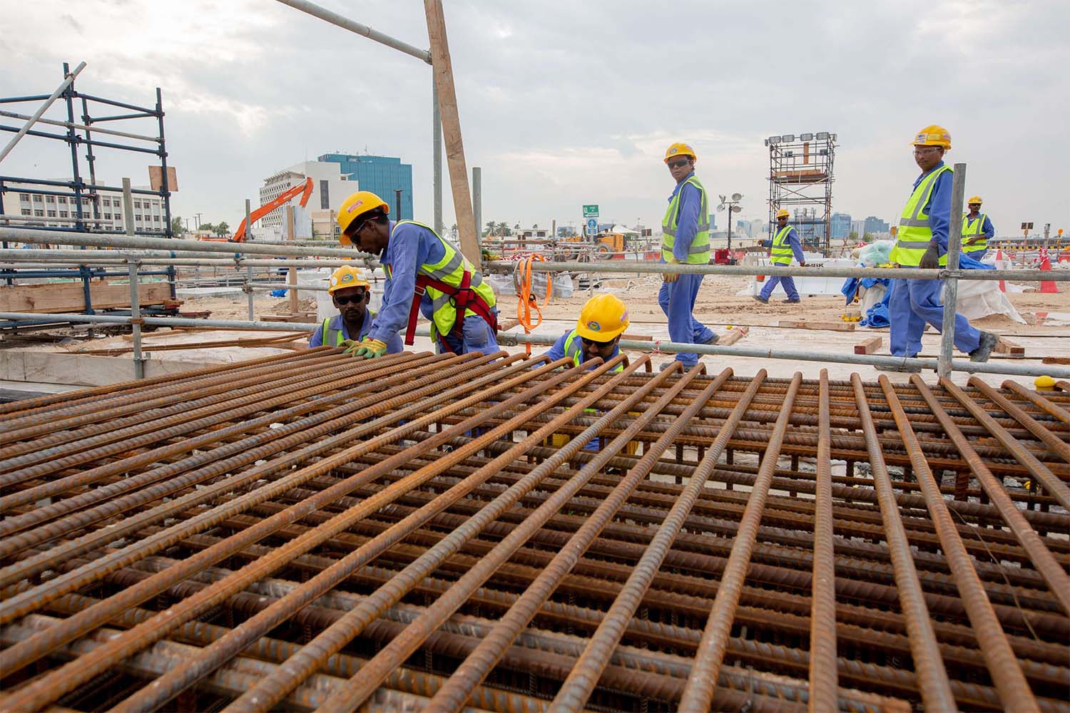 Construction workers work at the site of the Ras Abu Aboud Stadium in Doha