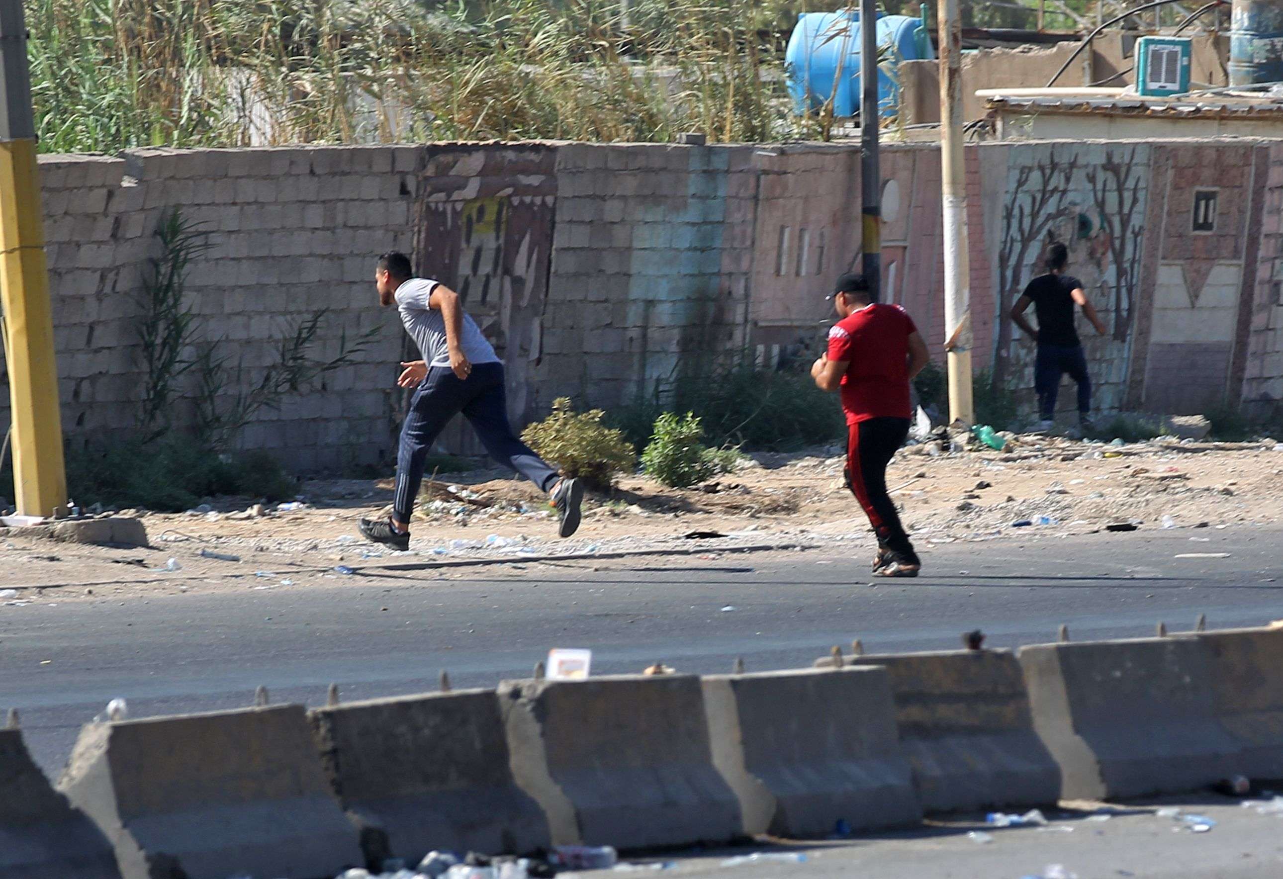 Iraqi protesters run during demonstration against state corruption and failing public services