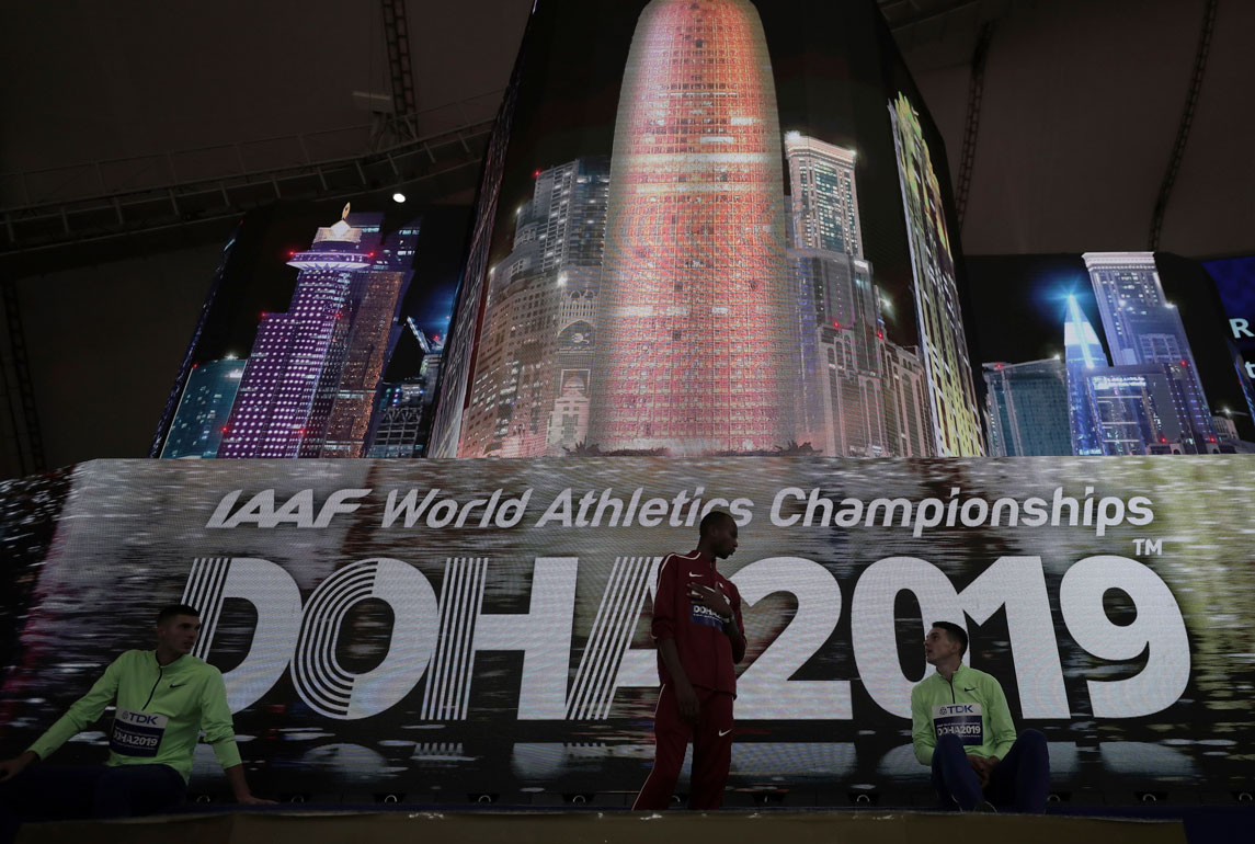 Athletes speak on the podium after the medal ceremony for the the men's high jump final was postponed