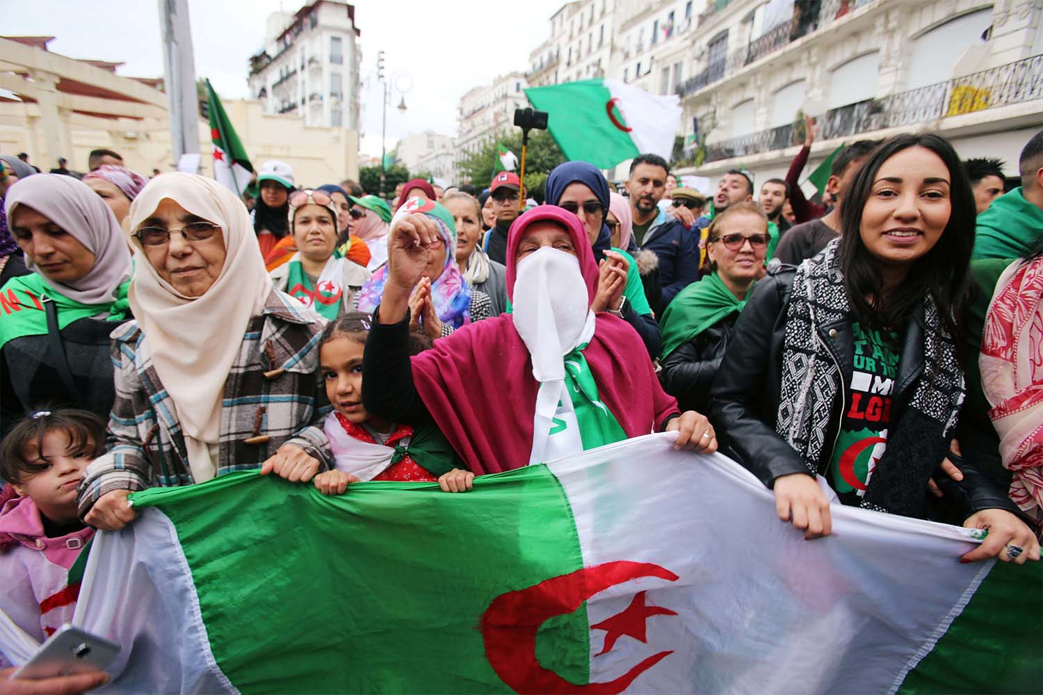 Demonstrators carry national flags during a protest rejecting the December presidential election in Algiers